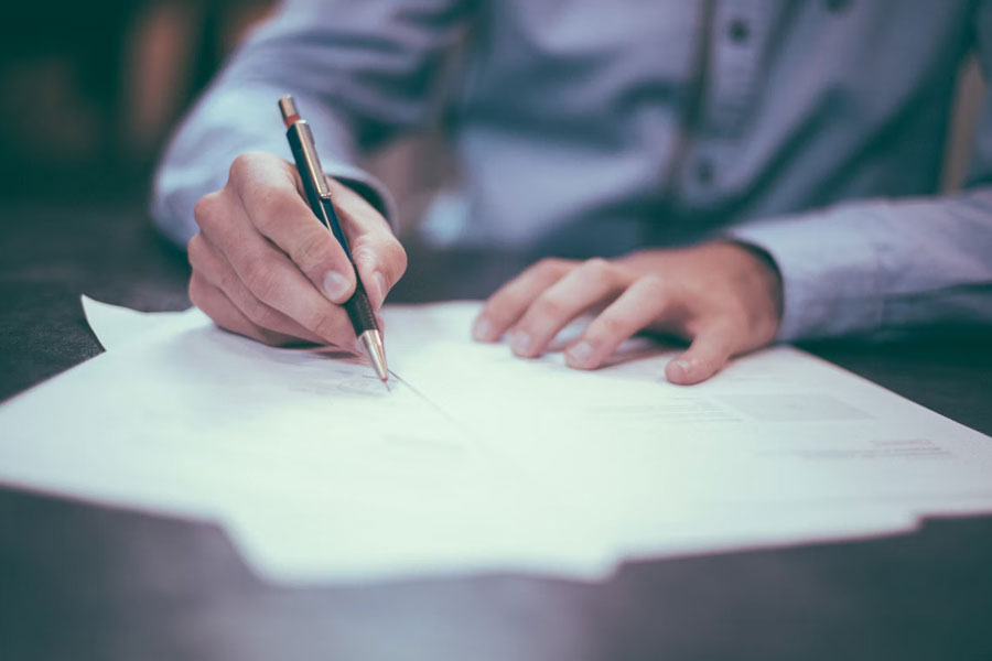 Close up of man signing documents